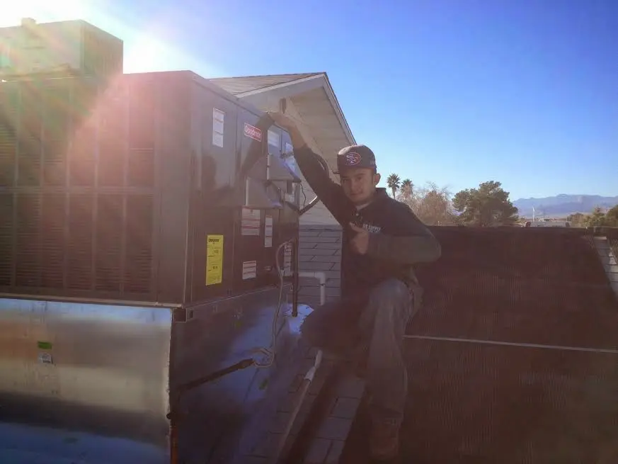HVAC technician performing Air Duct Cleaning on a rooftop unit in Everett